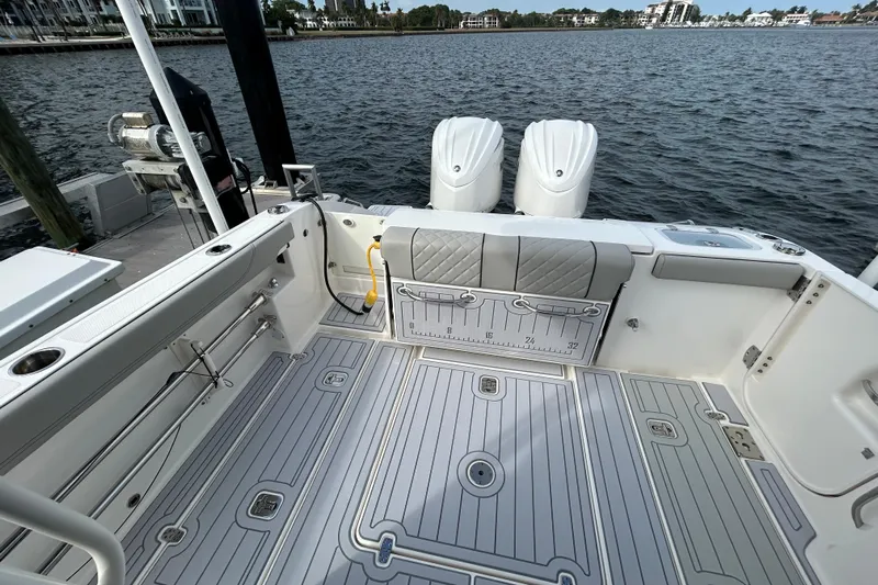  Yacht Photos Pics 2023 Pursuit S 288 Sport boat interior with dual engines, docked by the water.