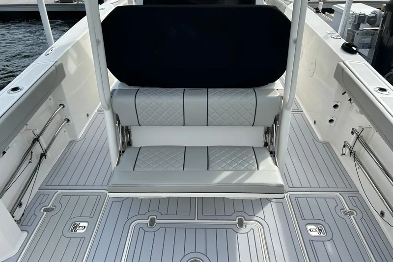  Yacht Photos Pics 2023 Pursuit S 288 Sport boat interior with cushioned seating and sleek flooring design.