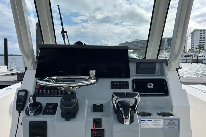  Yacht Photos Pics 2023 Pursuit S 288 Sport boat dashboard with steering wheel and controls.