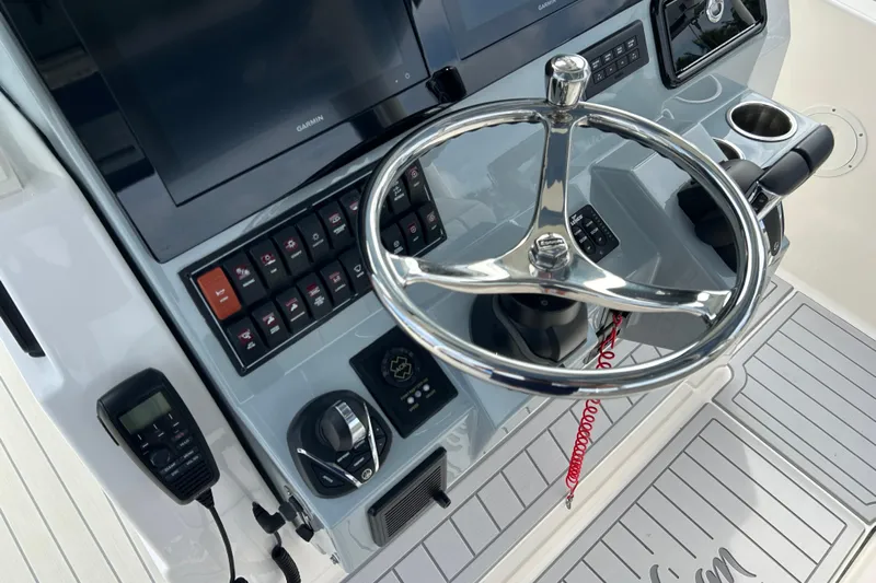  Yacht Photos Pics 2023 Pursuit S 288 Sport boat helm with steering wheel and control panel.