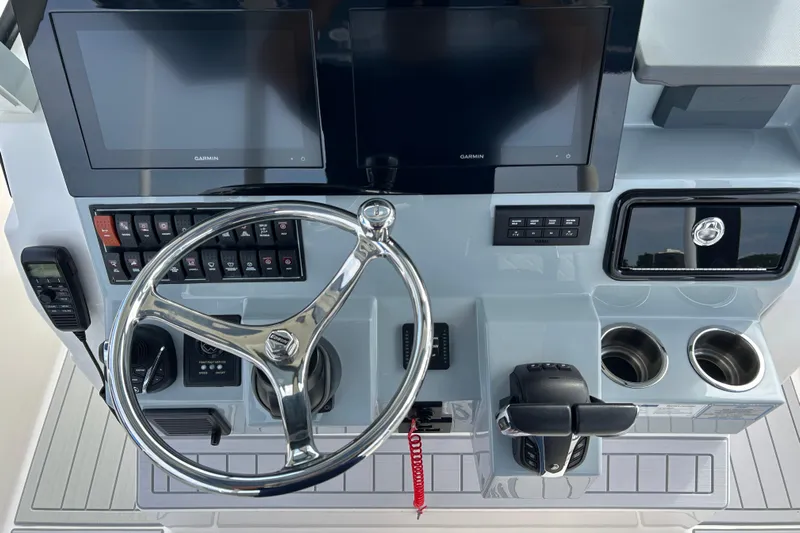  Yacht Photos Pics 2023 Pursuit S 288 Sport boat dashboard with steering wheel, controls, and Garmin displays.