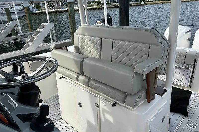  Yacht Photos Pics 2023 Pursuit S 288 Sport boat interior with quilted seating and steering wheel.