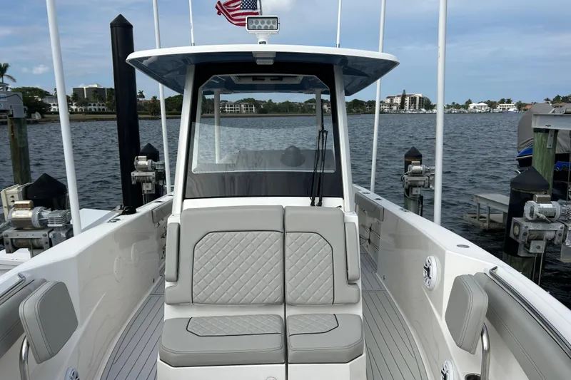  Yacht Photos Pics 2023 Pursuit S 288 Sport boat docked, featuring sleek seating and modern design.
