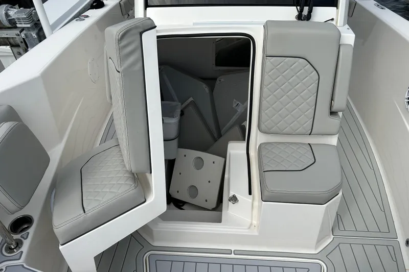  Yacht Photos Pics 2023 Pursuit S 288 Sport boat interior with gray cushioned seating and storage access.