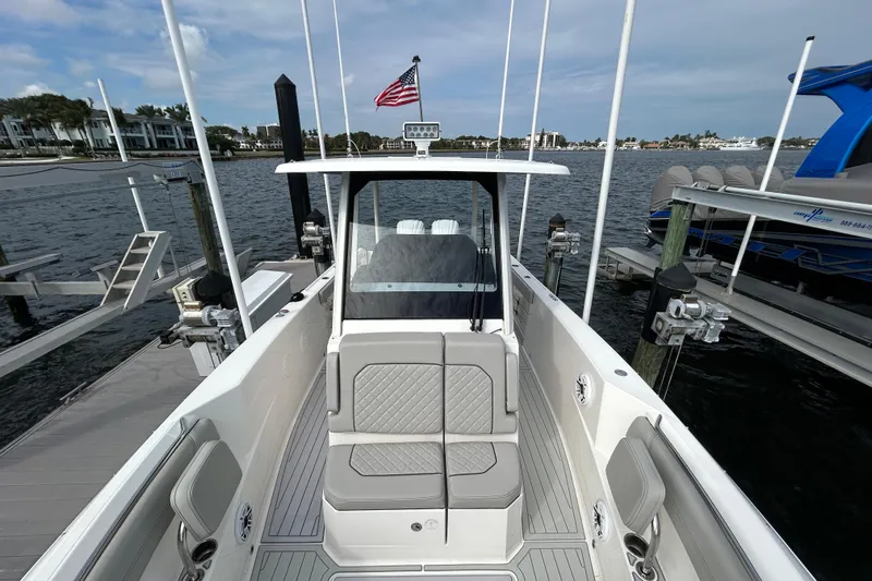  Yacht Photos Pics 2023 Pursuit S 288 Sport boat docked, featuring sleek design and comfortable seating.