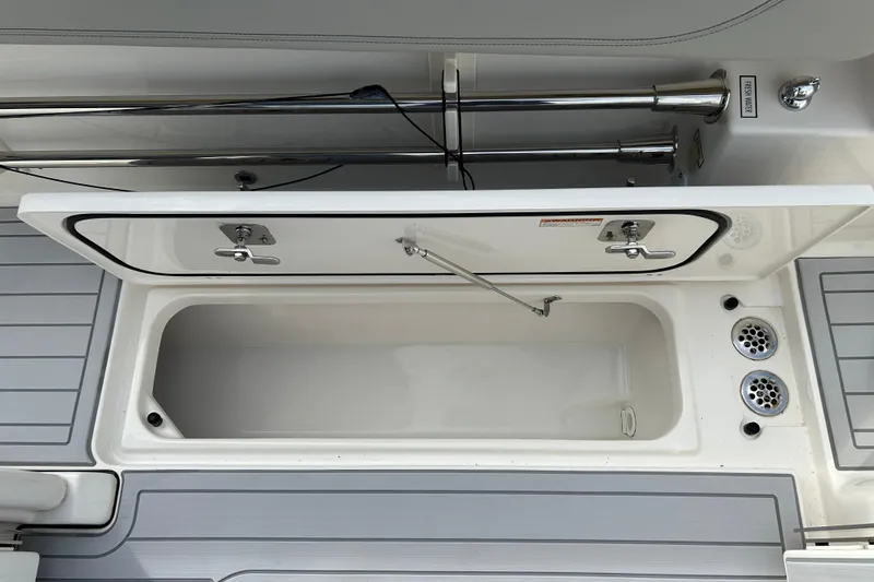  Yacht Photos Pics 2023 Pursuit S 288 Sport boat storage compartment with open lid and drainage system.