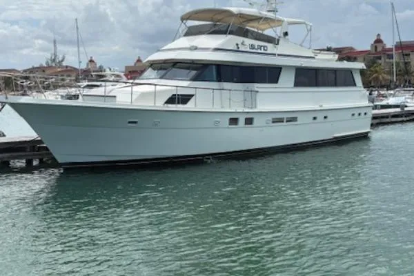 Island Yacht Photos Pics 1988 Hatteras 70 yacht docked in a marina, featuring a sleek white design.