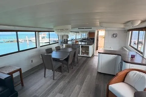Island Yacht Photos Pics Spacious interior of a 1988 Hatteras 70 yacht with modern dining area and ocean views.