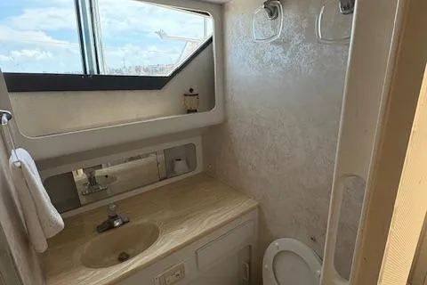 Island Yacht Photos Pics Bathroom interior of 1988 Hatteras 70 yacht with sink, toilet, and window view.