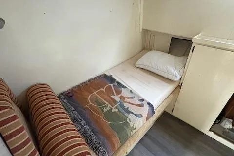 Island Yacht Photos Pics Cozy cabin interior of 1988 Hatteras 70 yacht with bed and striped cushions.