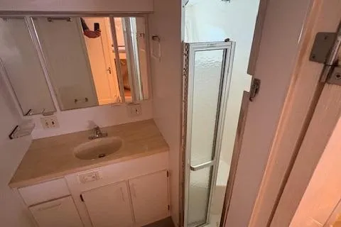 Island Yacht Photos Pics 1988 Hatteras 70 yacht bathroom with sink, mirror, and shower enclosure.