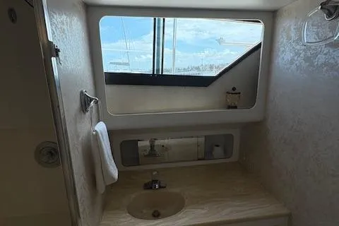 Island Yacht Photos Pics 1988 Hatteras 70 yacht bathroom with sink, mirror, and window view.