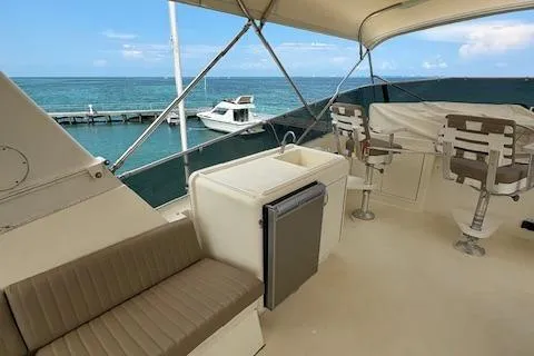 Island Yacht Photos Pics 1988 Hatteras 70 yacht deck with seating, ocean view, and marina backdrop.