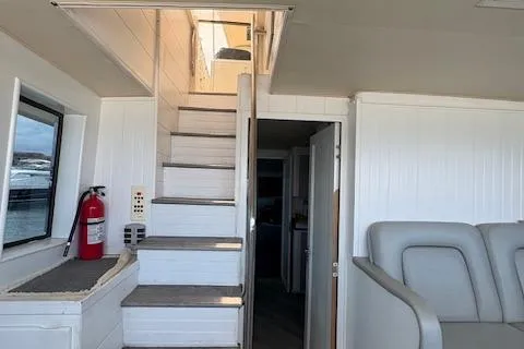 Island Yacht Photos Pics Interior of a 1988 Hatteras 70 yacht with stairs and seating area.