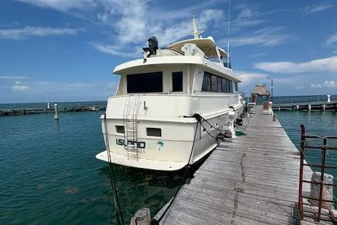 Island Yacht Photos Pics 1988 Hatteras 70 yacht docked at a marina under a clear blue sky.