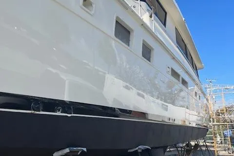 Island Yacht Photos Pics 1988 Hatteras 70 yacht with sleek white exterior, docked under clear blue sky.
