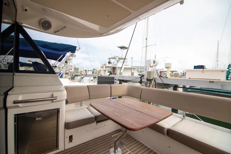 Hoff Yacht Photos Pics 2016 Regal 42 Grande Coupe yacht interior with seating and wooden table at marina.