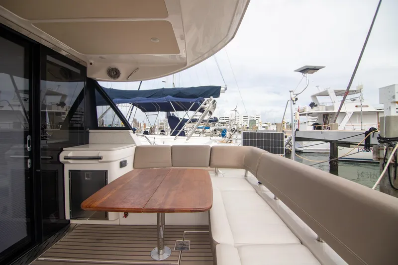 Hoff Yacht Photos Pics 2016 Regal 42 Grande Coupe yacht with spacious outdoor seating and wooden table.