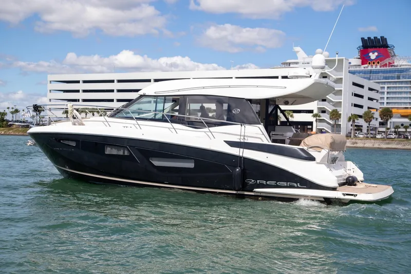 Hoff Yacht Photos Pics 2017 Regal 42 Grande Coupe yacht cruising in sunny waters near a modern marina.