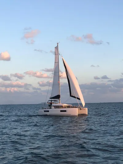 Cloud II Yacht Photos Pics 2023 Lagoon 40 catamaran sailing on open sea at sunset.