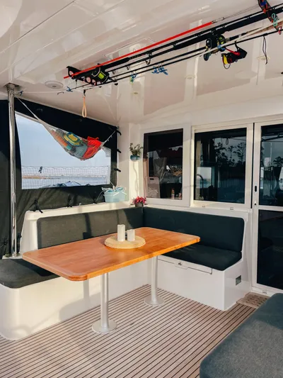 Cloud II Yacht Photos Pics 2023 Lagoon 40 yacht interior with seating, table, and fishing rods.