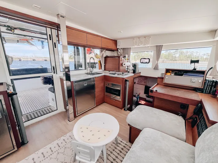 Cloud II Yacht Photos Pics Modern interior of 2023 Lagoon 40 catamaran with kitchen, seating, and navigation area.