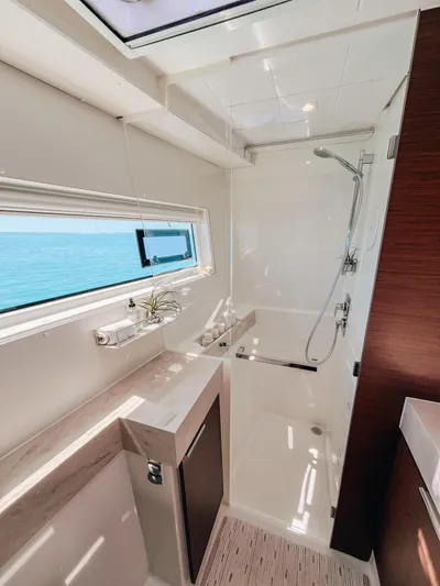 Cloud II Yacht Photos Pics Modern bathroom interior on 2023 Lagoon 40 yacht with ocean view window.