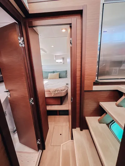 Cloud II Yacht Photos Pics Interior of 2023 Lagoon 40 yacht showing cozy bedroom and wooden stairs.