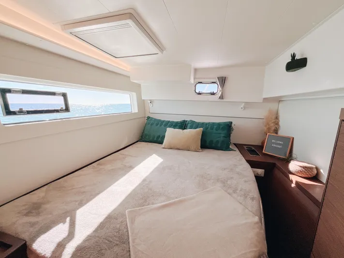 Cloud II Yacht Photos Pics Luxurious cabin interior of 2023 Lagoon 40 catamaran with ocean view and cozy bedding.