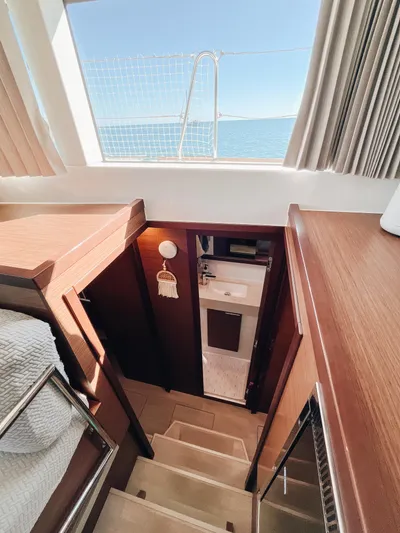 Cloud II Yacht Photos Pics Interior of 2023 Lagoon 40 yacht, featuring wooden stairs and a bathroom view.