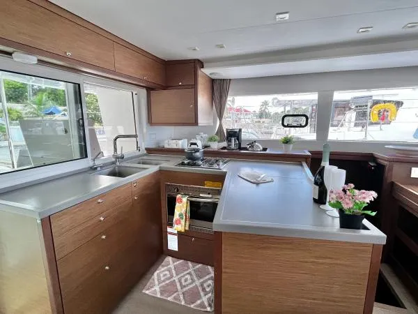 Smooth Sailor Yacht Photos Pics Modern kitchen interior of 2019 Lagoon 450 yacht with wood cabinetry and stainless steel appliances.