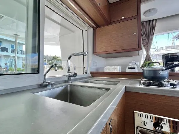Smooth Sailor Yacht Photos Pics Modern kitchen interior of 2019 Lagoon 450 catamaran with stainless steel sink and stove.