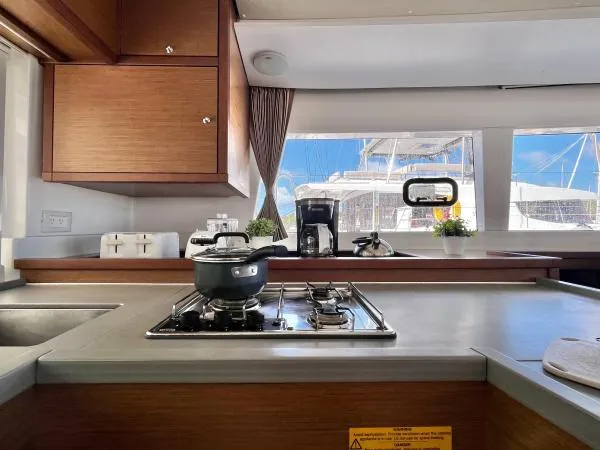 Smooth Sailor Yacht Photos Pics Interior of 2019 Lagoon 450 yacht kitchen with stove, pot, and window view of marina.