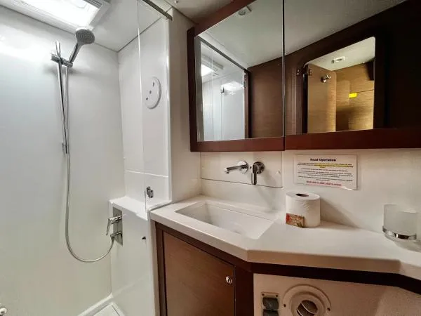 Smooth Sailor Yacht Photos Pics Bathroom interior of 2019 Lagoon 450 yacht, featuring shower, sink, and mirror.