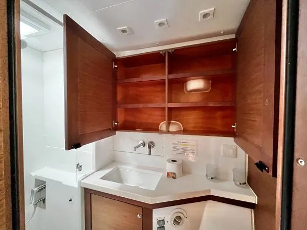 Smooth Sailor Yacht Photos Pics Bathroom interior of 2019 Lagoon 450 yacht with wooden cabinets and white sink.