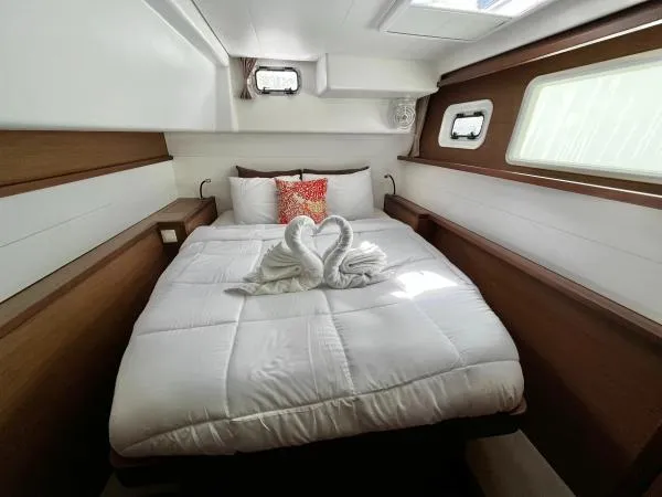 Smooth Sailor Yacht Photos Pics Luxurious cabin interior of 2019 Lagoon 450 catamaran with elegant bedding and decorative swan towels.