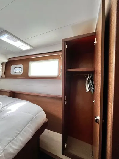 Smooth Sailor Yacht Photos Pics Interior of 2019 Lagoon 450 yacht cabin with open wooden wardrobe and bed.