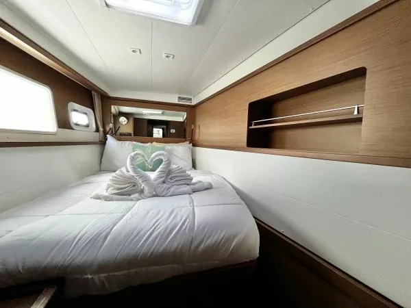Smooth Sailor Yacht Photos Pics Cozy cabin interior of 2019 Lagoon 450 yacht with elegant bedding and wooden accents.