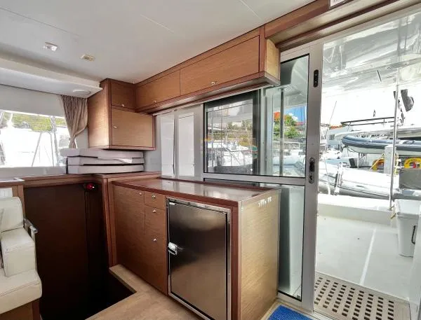 Smooth Sailor Yacht Photos Pics Interior of 2019 Lagoon 450 yacht with modern wood cabinetry and sliding glass door.