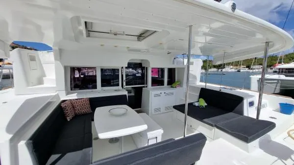 Smooth Sailor Yacht Photos Pics 2019 Lagoon 450 yacht interior with spacious seating and table, docked at marina.