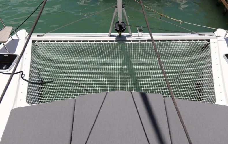 Wish You Were Here Yacht Photos Pics Fountaine Pajot Lucia 40 catamaran net deck, 2020 model, over turquoise water.