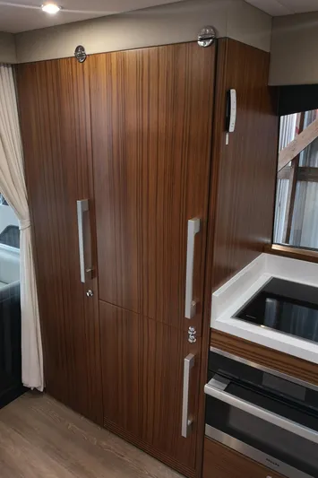 City Lights Yacht Photos Pics Luxurious wood-paneled interior of 2021 Maritimo X50 yacht kitchen area.