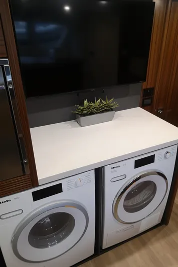 City Lights Yacht Photos Pics Laundry area in a 2021 Maritimo X50 yacht with washer, dryer, and countertop.