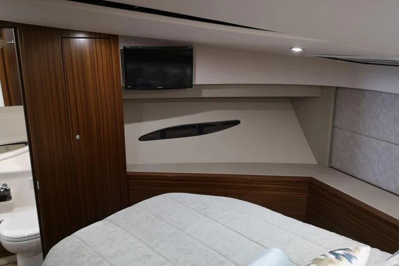 City Lights Yacht Photos Pics 2021 Maritimo X50 yacht interior with wood paneling, bed, TV, and bathroom view.