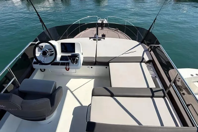  Yacht Photos Pics 2024 Jeanneau Merry Fisher 1095 Flybridge with helm and seating, on calm water.