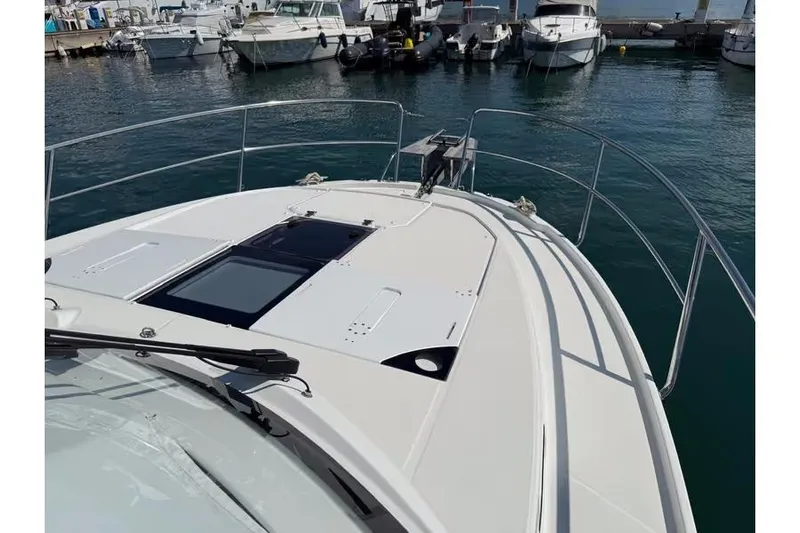  Yacht Photos Pics 2024 Jeanneau Merry Fisher 1095 Fly yacht docked at marina, showcasing sleek deck design.