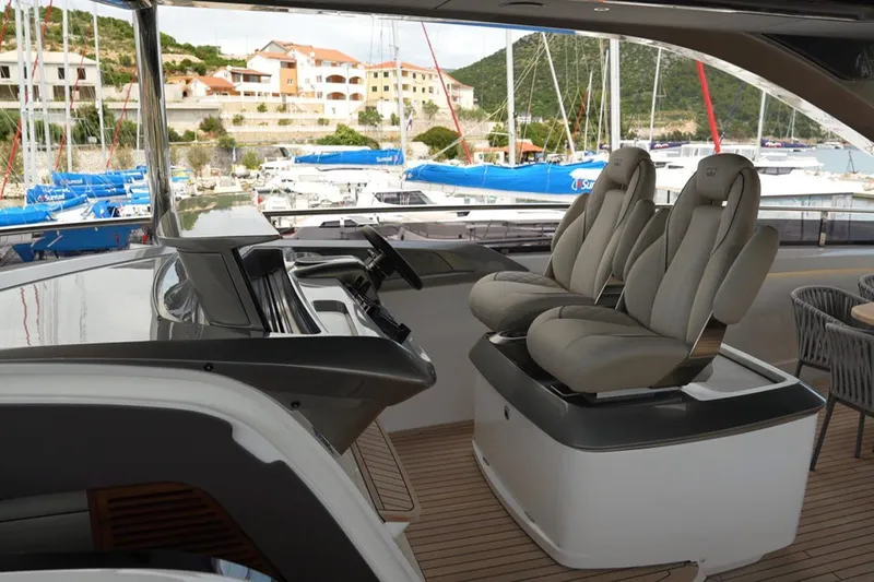  Yacht Photos Pics Luxurious 2025 Princess Y95 yacht helm with plush seating and marina view.