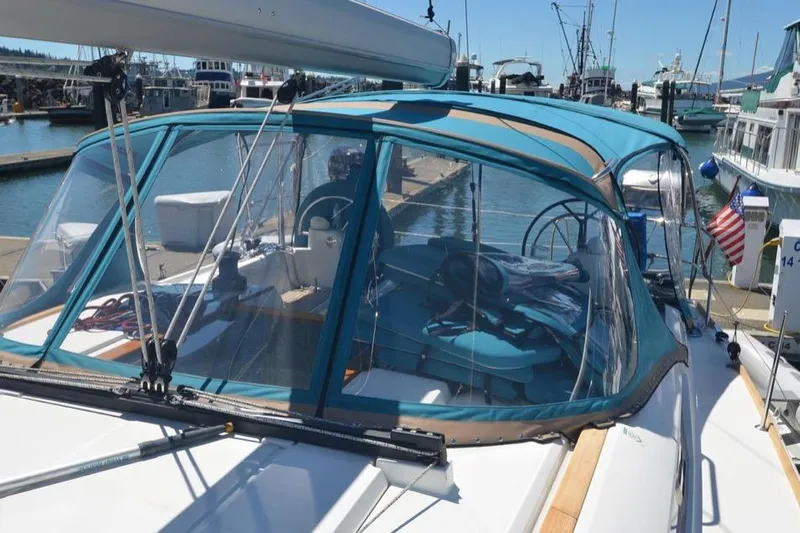 Leah Yacht Photos Pics 2014 Jeanneau Sun Odyssey 469 sailboat docked at marina with blue canopy.