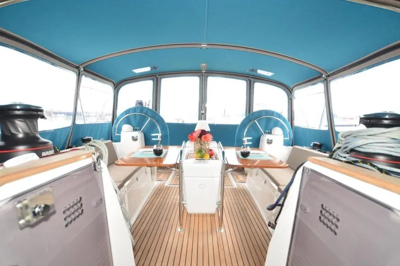 Leah Yacht Photos Pics 2014 Jeanneau Sun Odyssey 469 yacht interior with blue canopy and wooden deck.