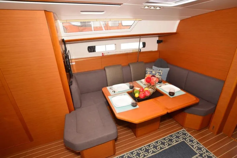 Leah Yacht Photos Pics Interior of 2014 Jeanneau Sun Odyssey 469 yacht with cozy dining area and elegant wood finish.